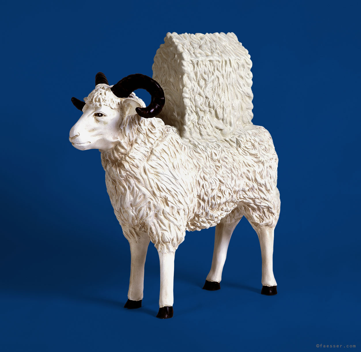 A sheep has a house mutation on his back; work of art; artist Roland Faesser, sculptor and painter 1999