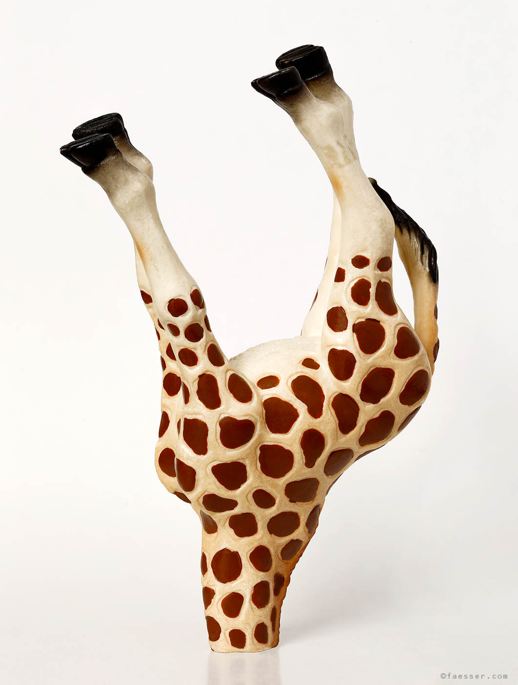 A giraffe puts his head in the ground; work of art as figurative sculpture; artist Roland Faesser, sculptor and painter 2019